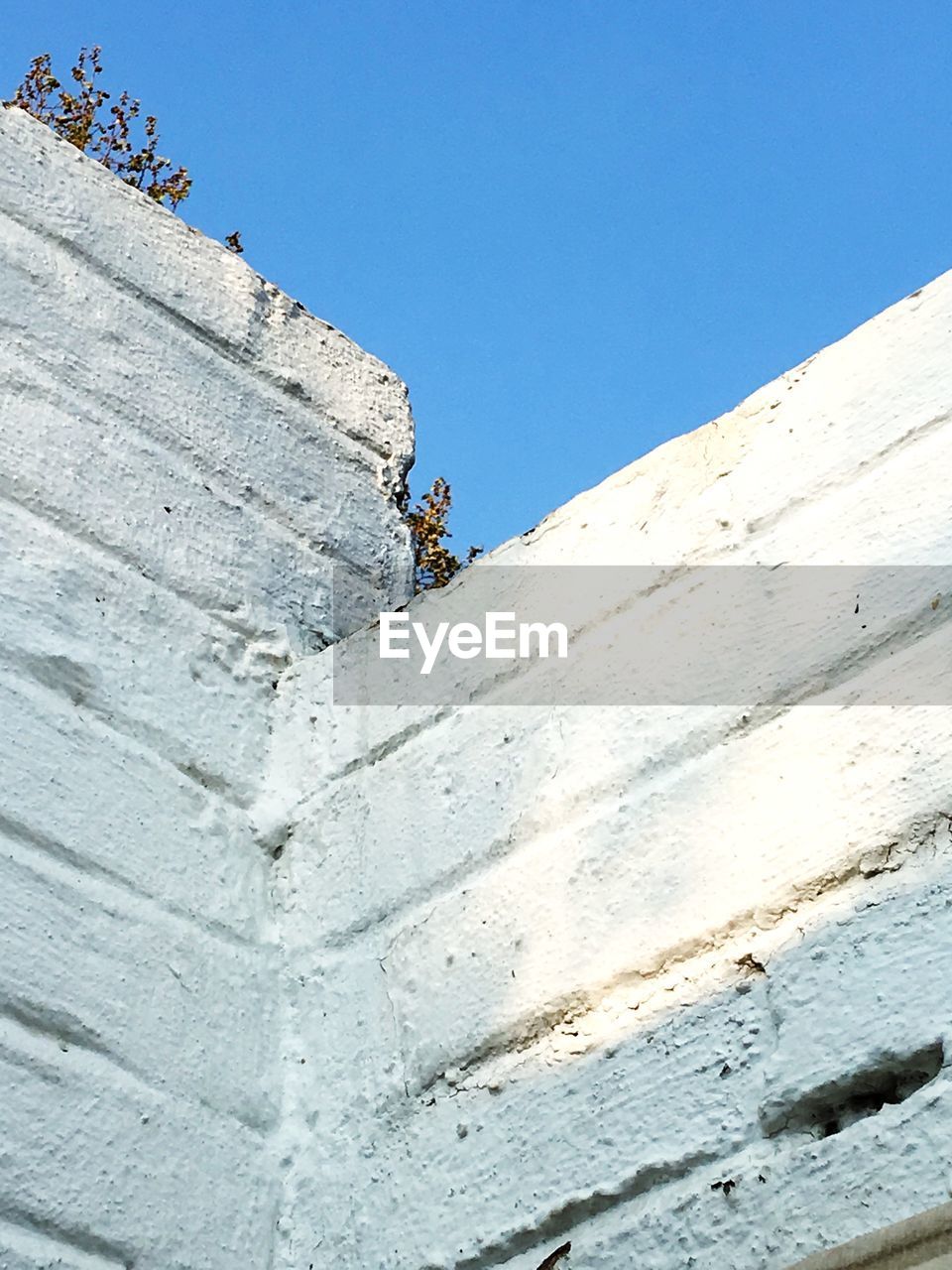 LOW ANGLE VIEW OF MEN CLIMBING AGAINST BLUE SKY