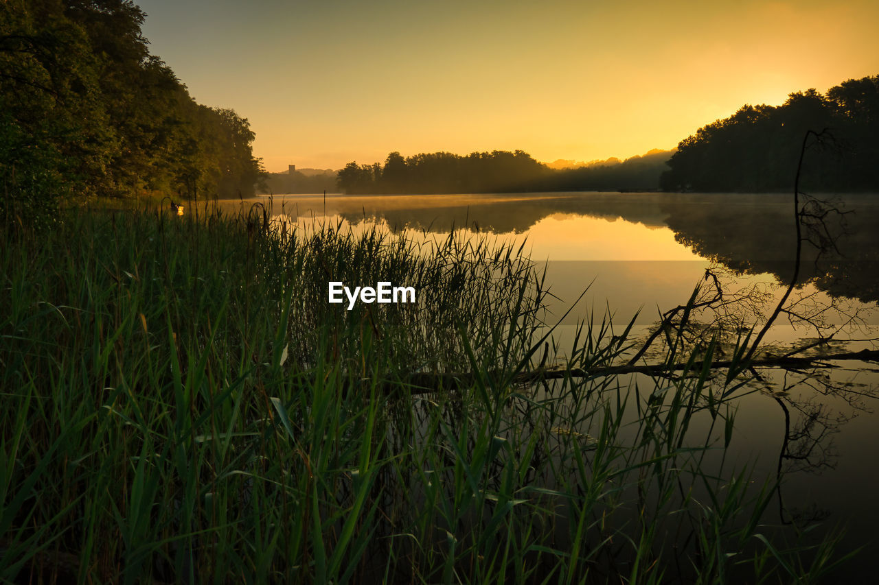 Scenic view of lake against sky during sunrise