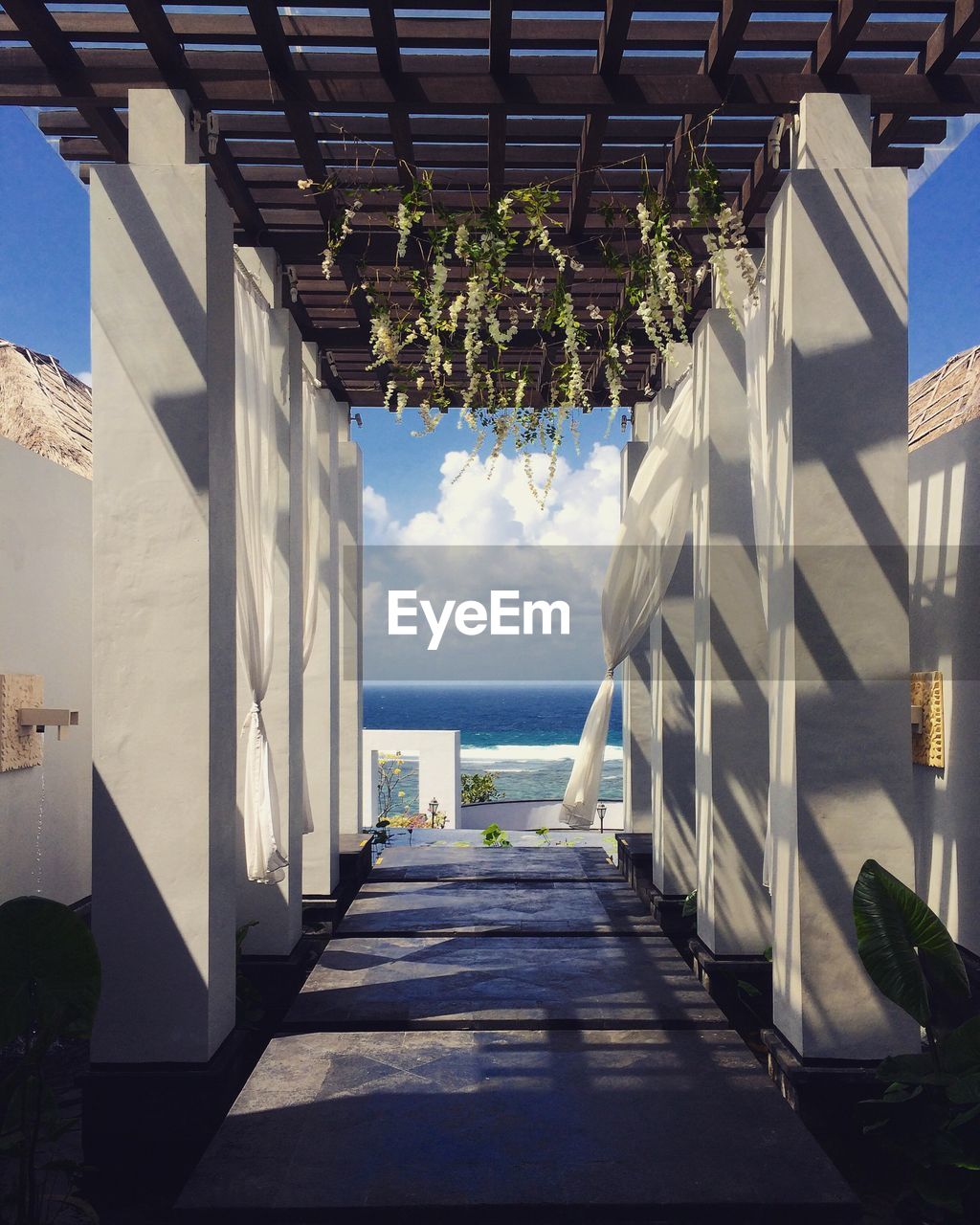 Empty colonnade at beach against sky