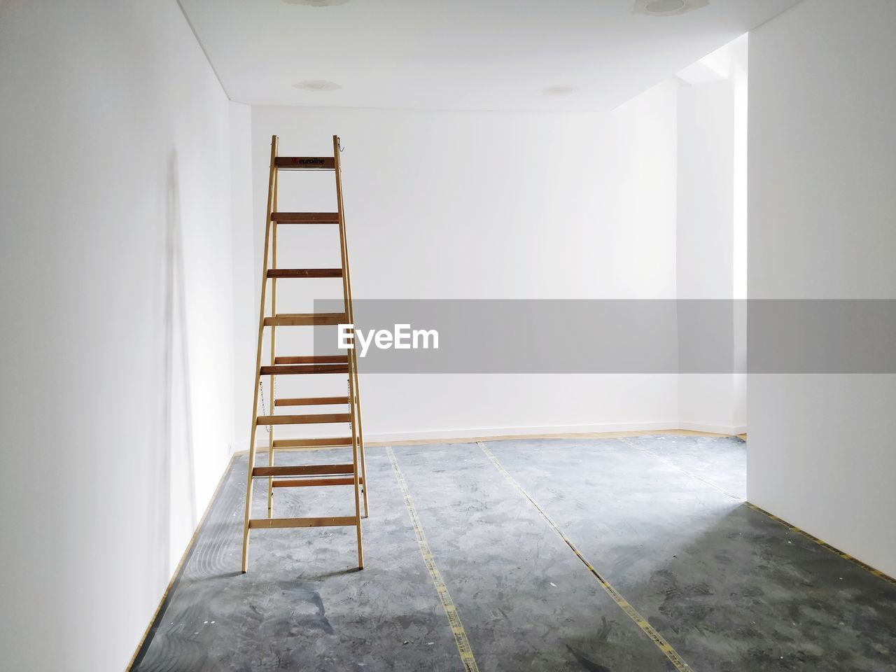 Empty white room with ladder being renovated