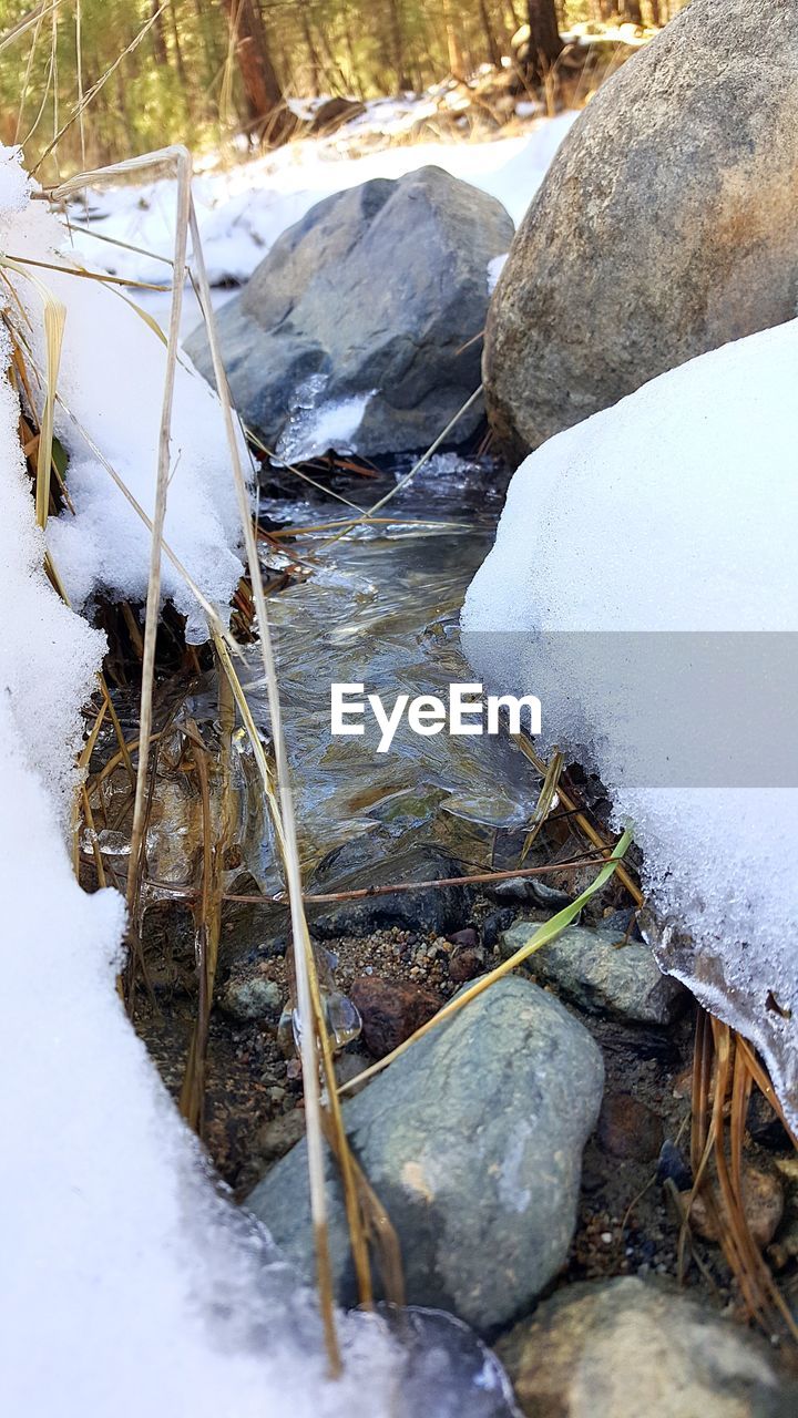 HIGH ANGLE VIEW OF FROZEN RIVER AMIDST SNOW