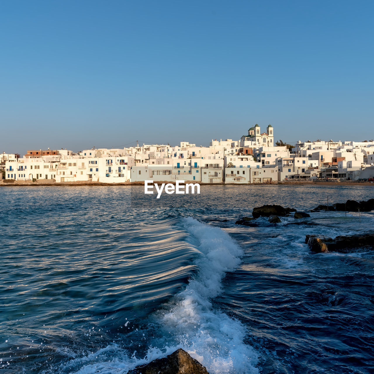 Scenic view of sea and buildings against clear sky