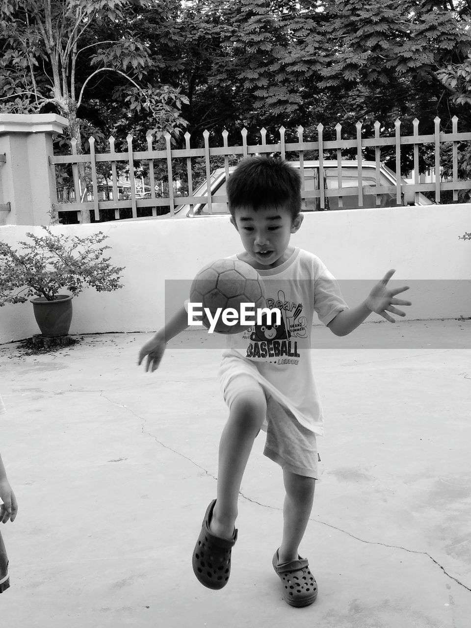 Full length of boy playing soccer at yard