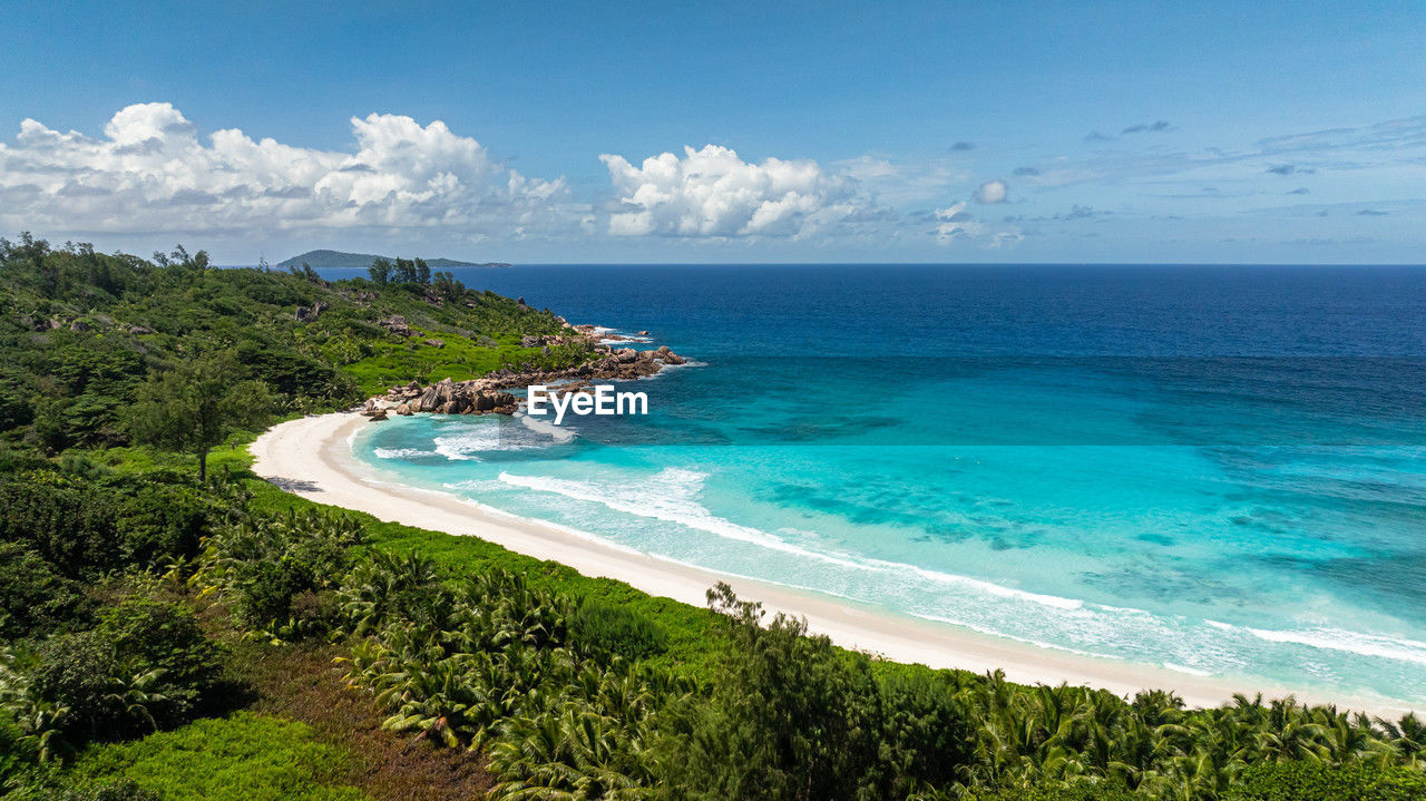 A secluded cove with calm turquoise waters and white sandy beach. seychelles, la digue. anse cocos.