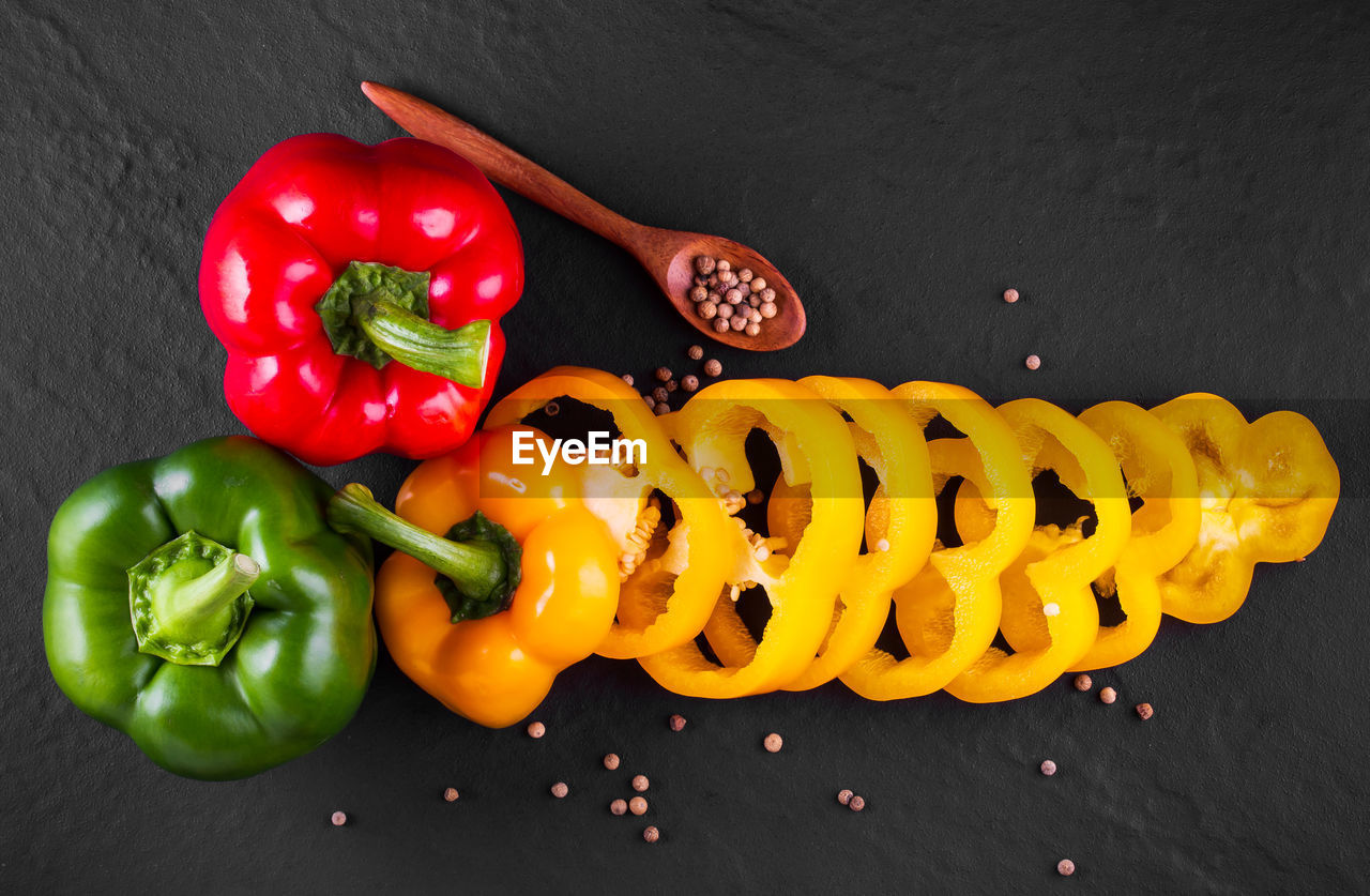 HIGH ANGLE VIEW OF BELL PEPPERS AND VEGETABLES ON TABLE