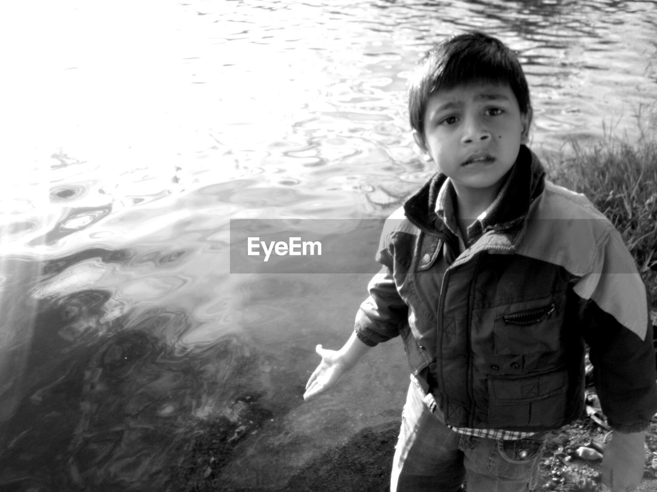 Portrait of boy showing lake water