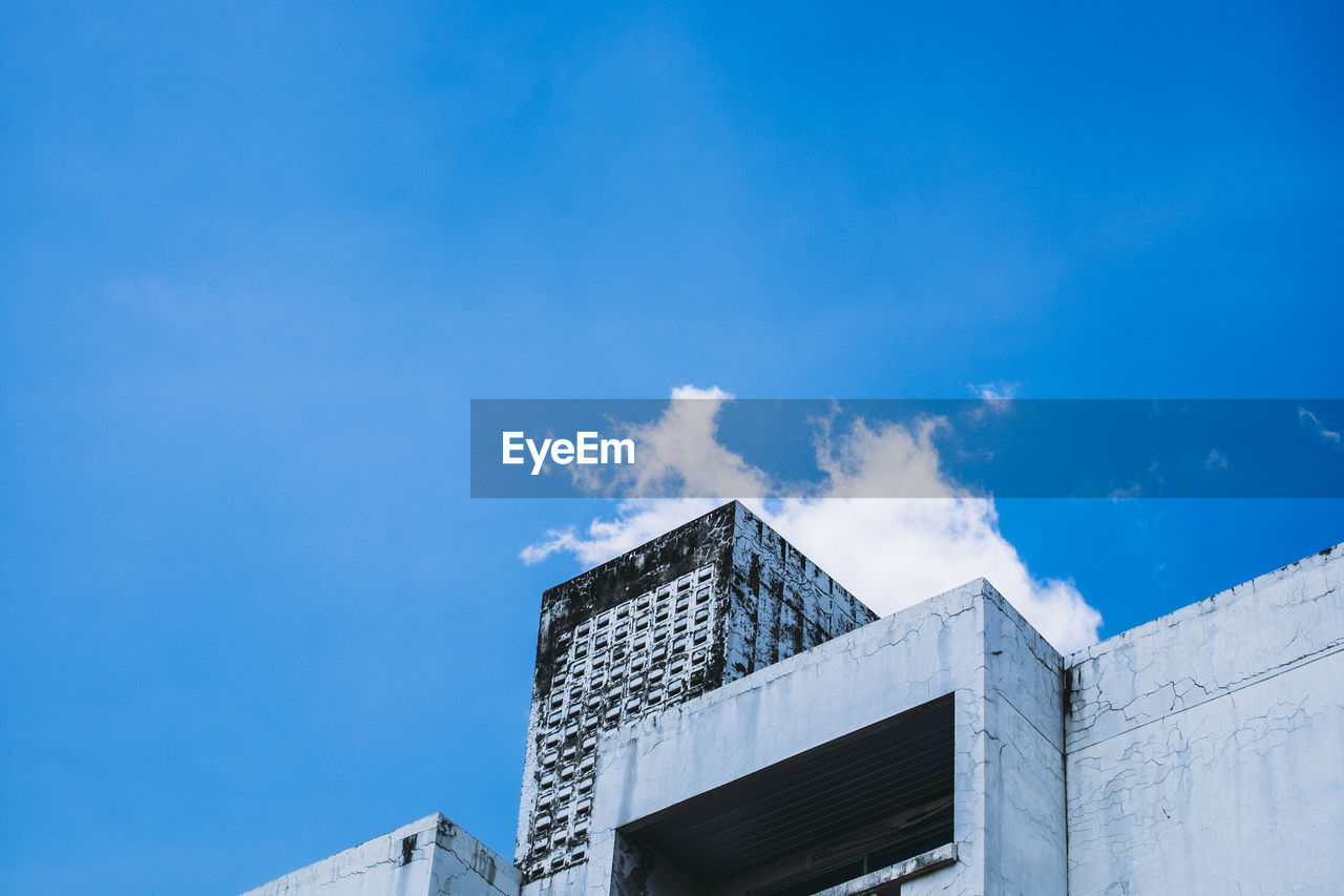 LOW ANGLE VIEW OF MODERN BUILDING AGAINST BLUE SKY