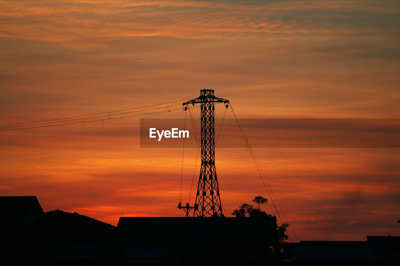 low angle view of silhouette electricity pylon against orange sky