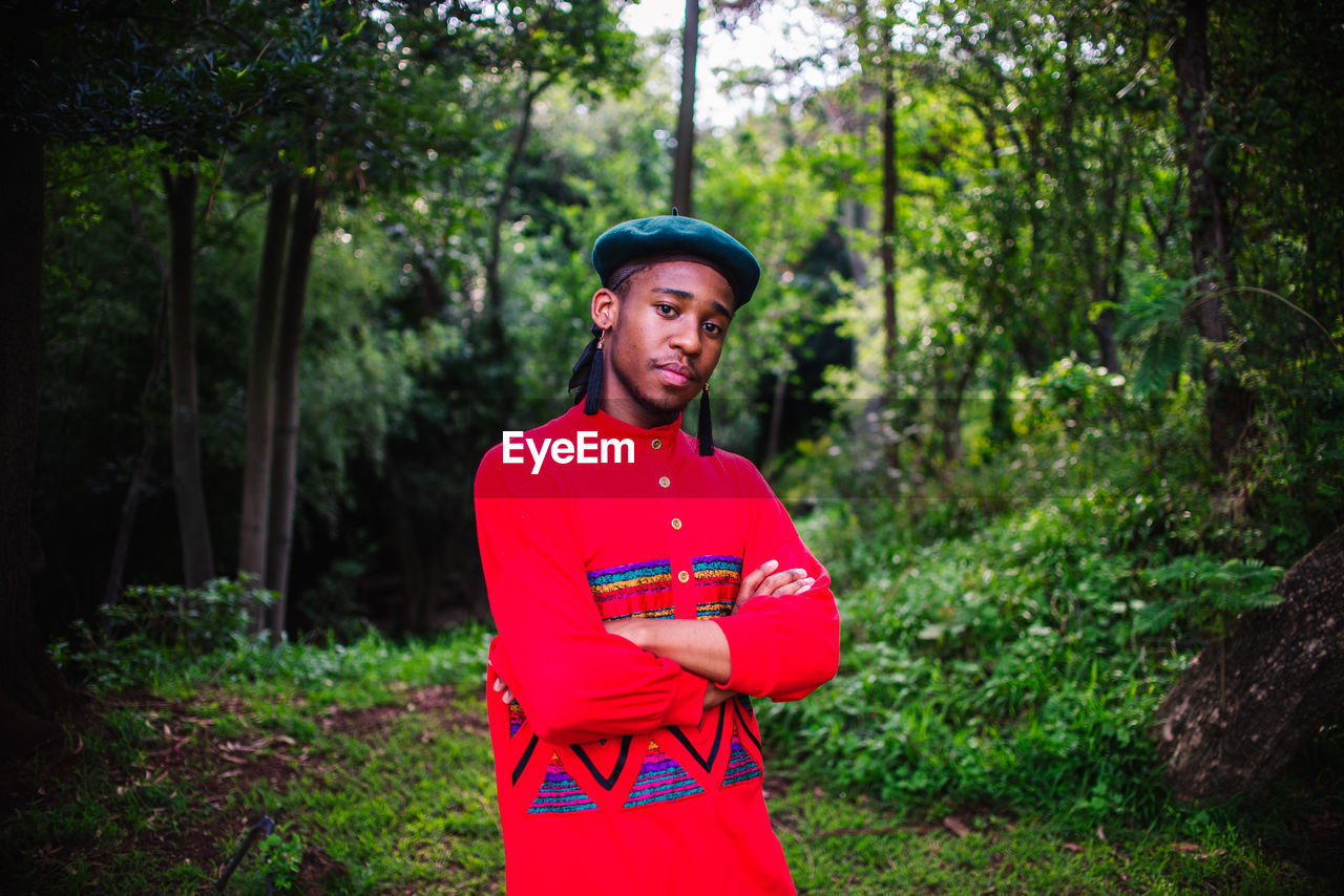 HAPPY YOUNG MAN STANDING IN FOREST