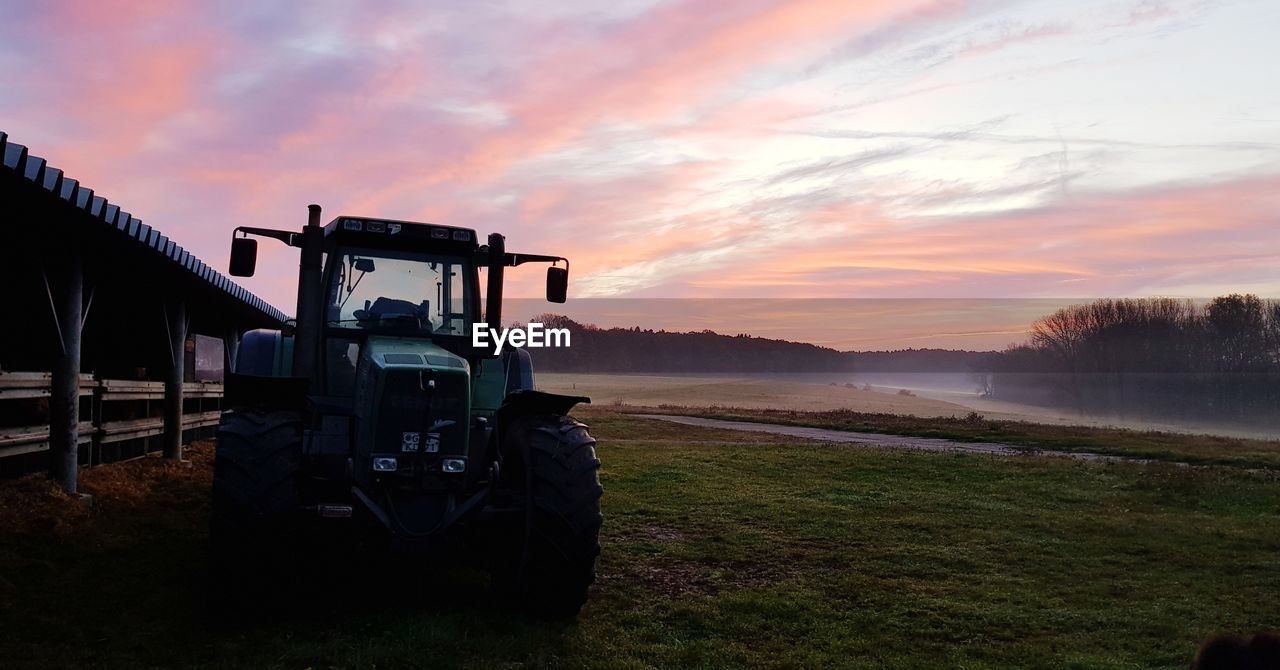 TRAIN ON FIELD AGAINST SKY DURING SUNSET