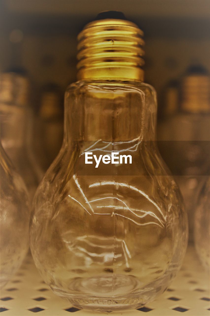 CLOSE-UP OF GLASS BOTTLE WITH JAR ON TABLE