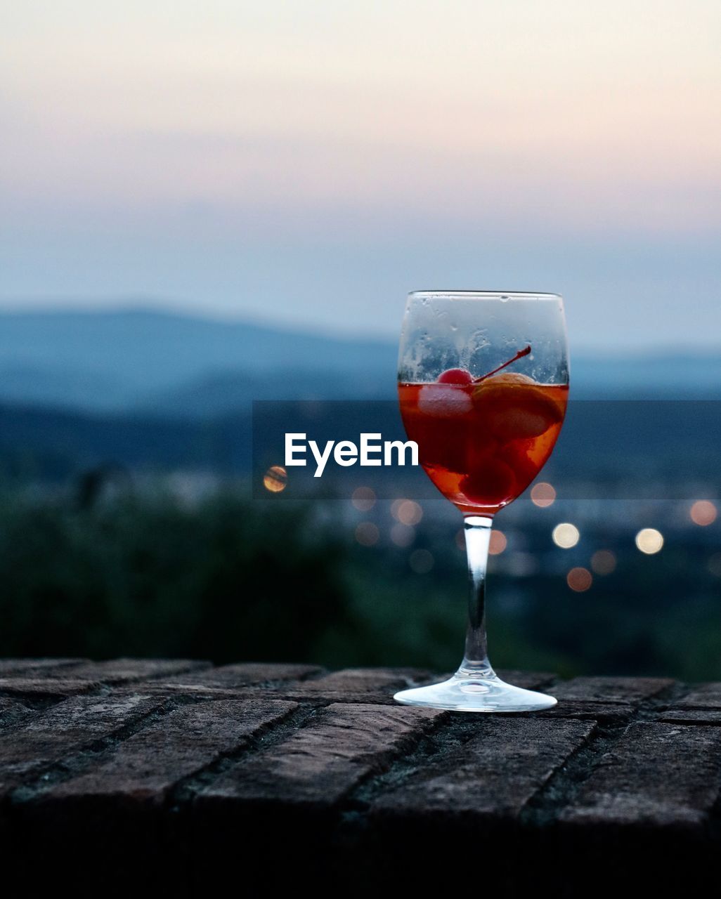 CLOSE-UP OF BEER ON TABLE AGAINST SKY DURING SUNSET