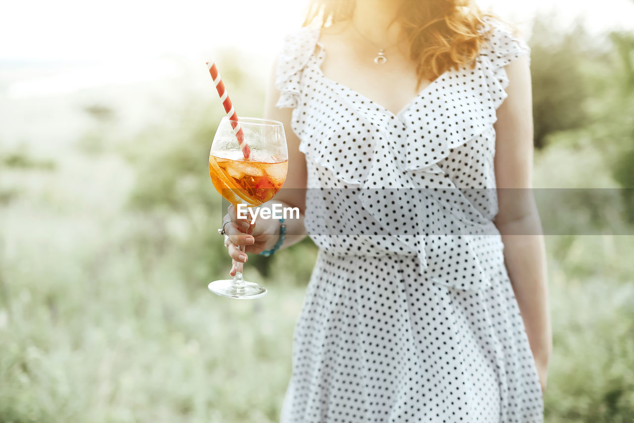 MIDSECTION OF WOMAN HOLDING ICE CREAM