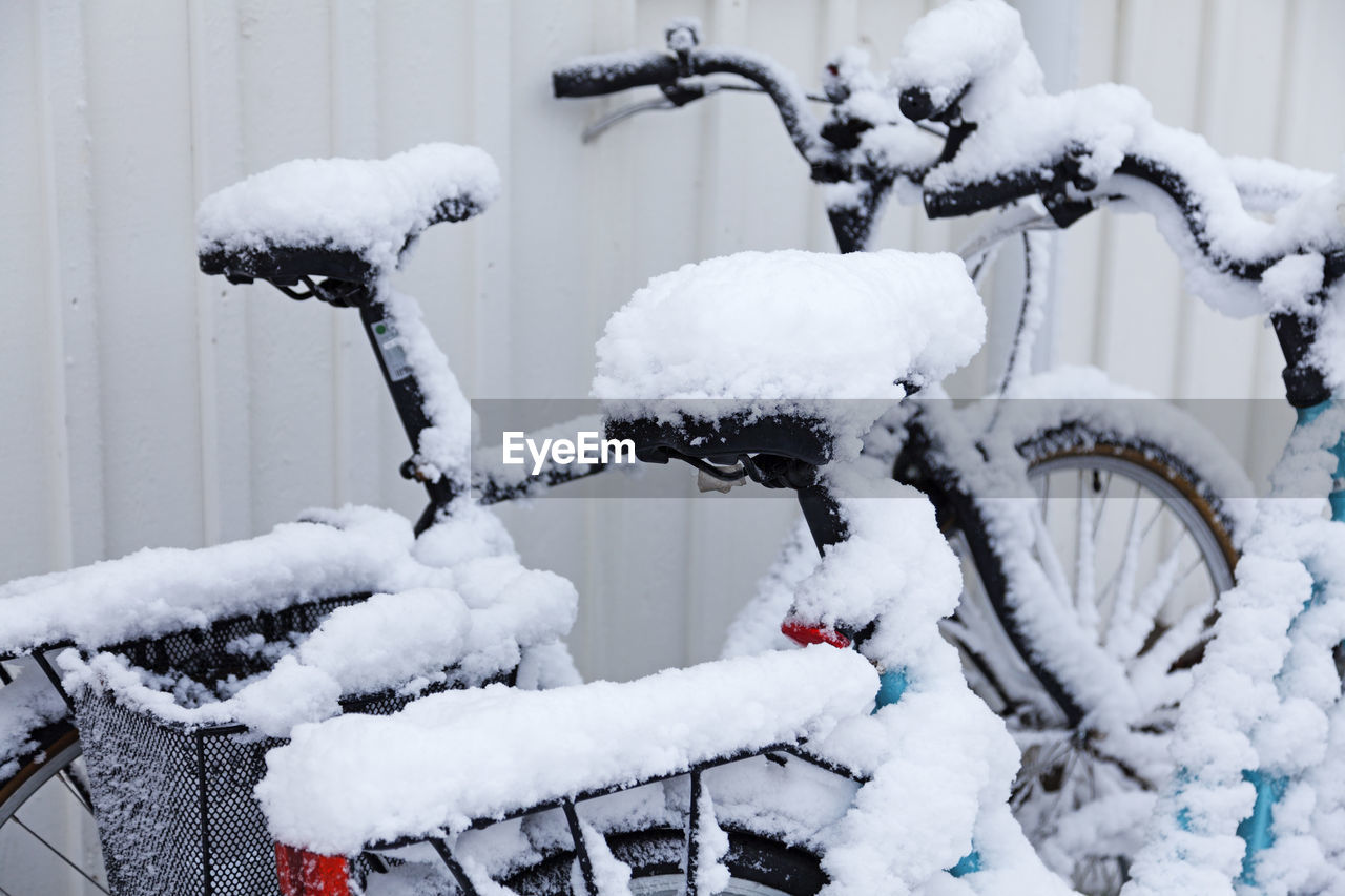 Snow-covered bikes next to each other