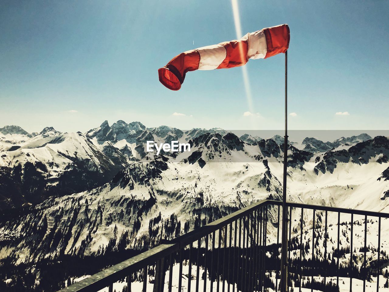 RED FLAG ON SNOWCAPPED MOUNTAIN AGAINST SKY