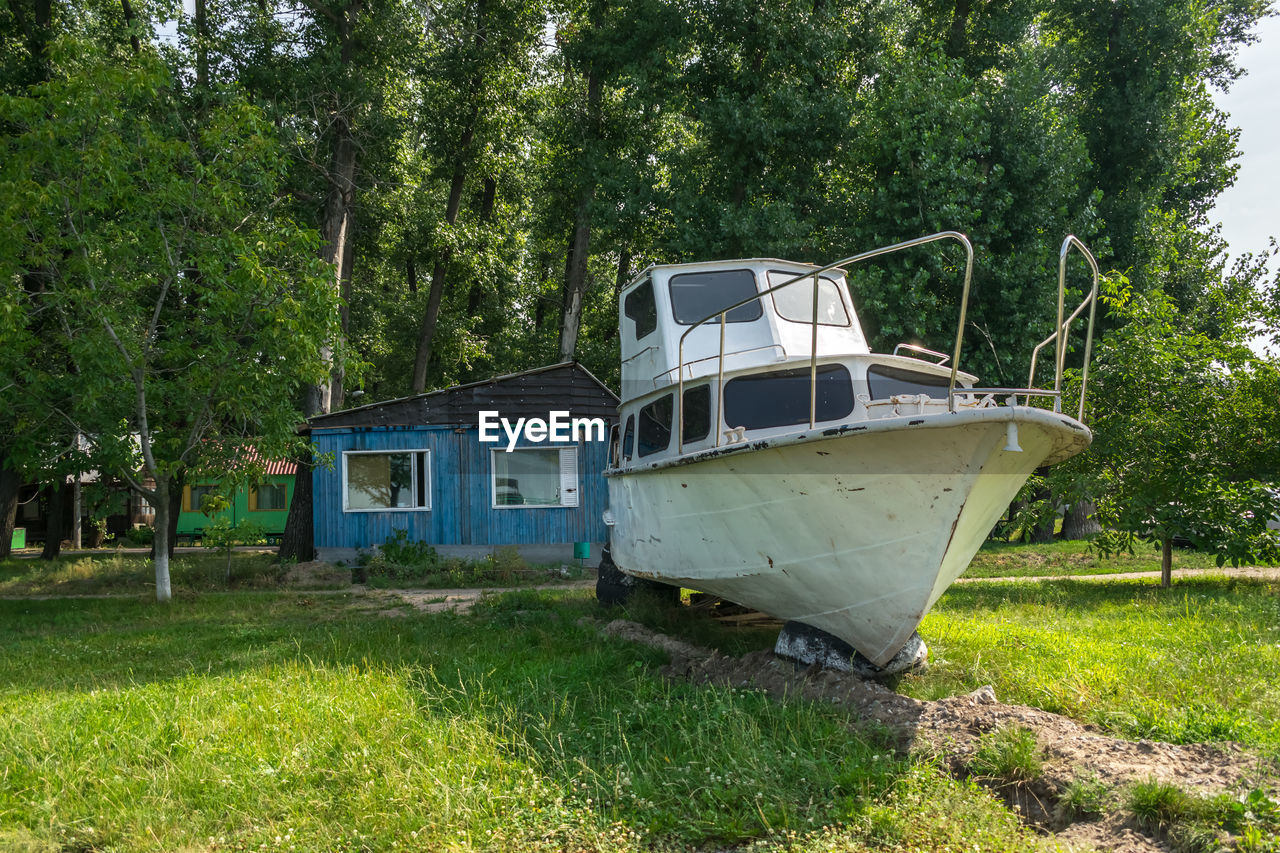 Old sailing yacht on land. old white motor yacht beached at a dock for painting and repair