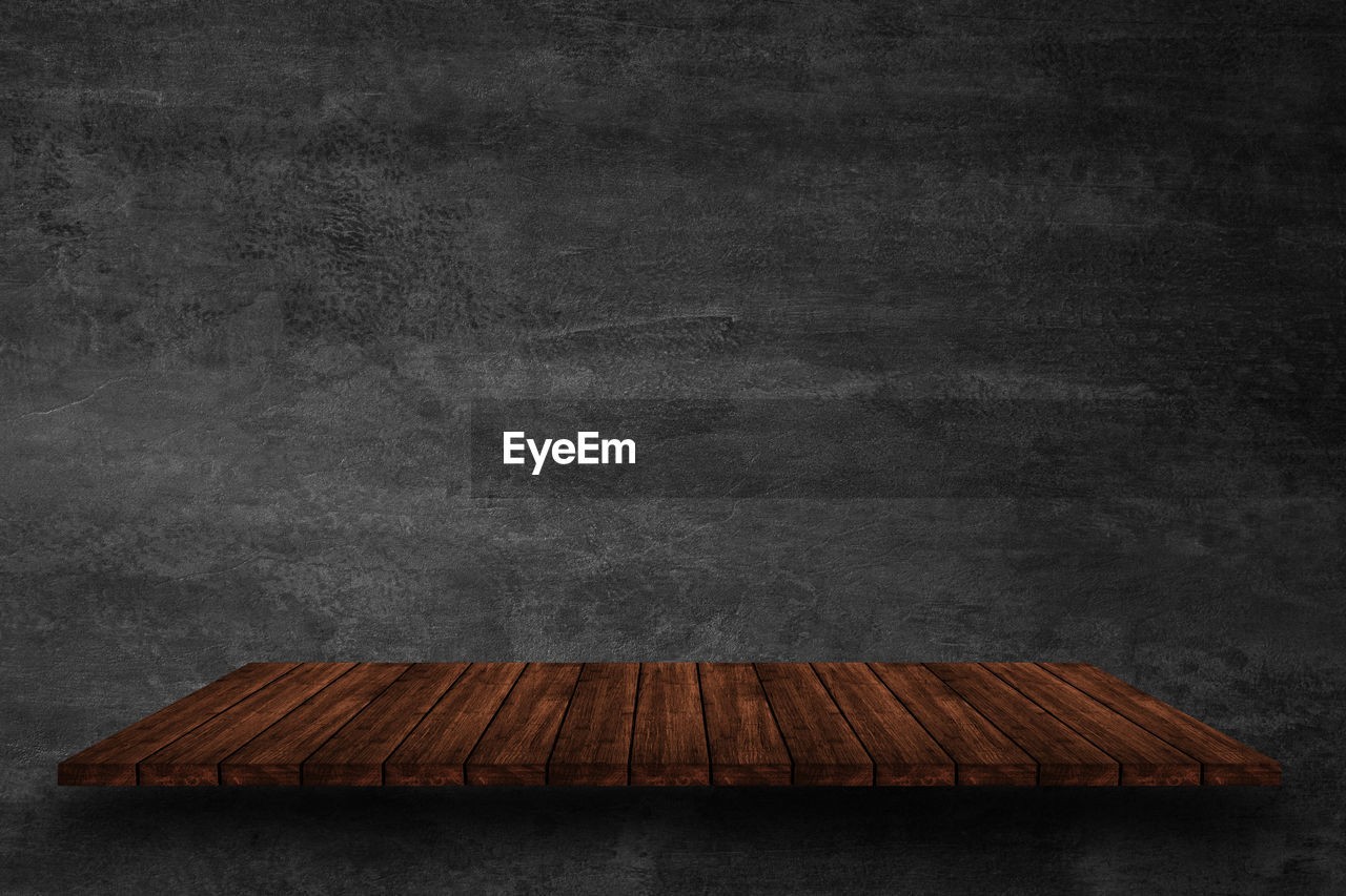 EMPTY WOODEN TABLE AGAINST THE WALL