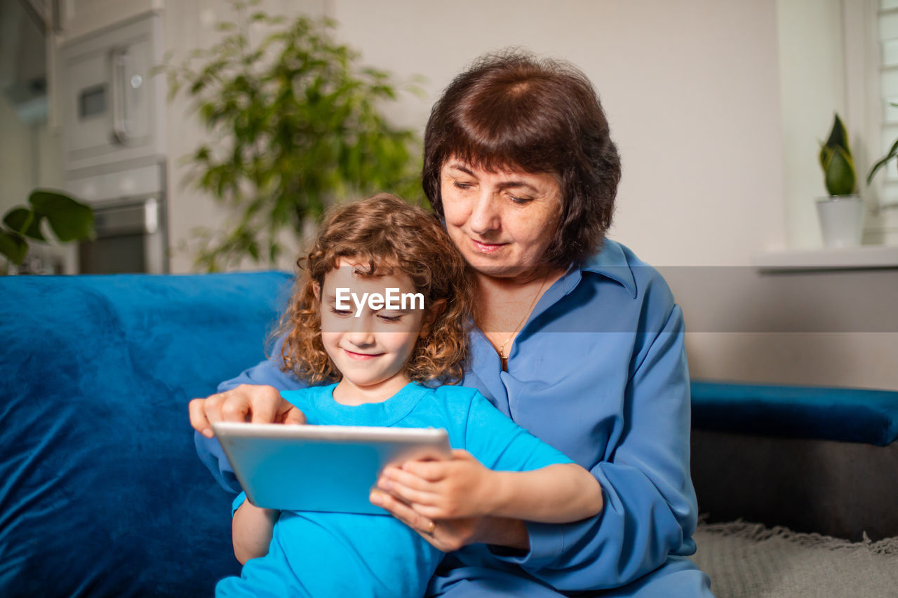 Boy sitting on mobile phone at home