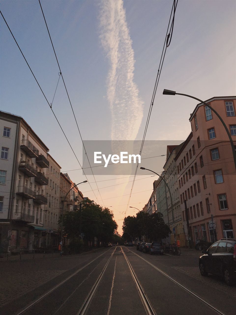 Road in city against sky at sunset