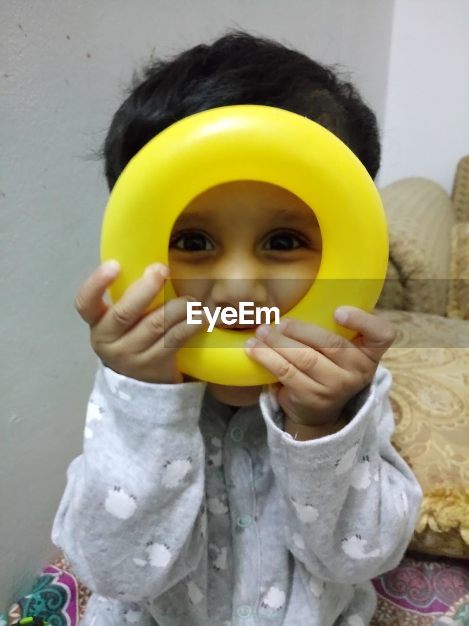 PORTRAIT OF CUTE BABY GIRL HOLDING YELLOW WHILE WEARING MASK