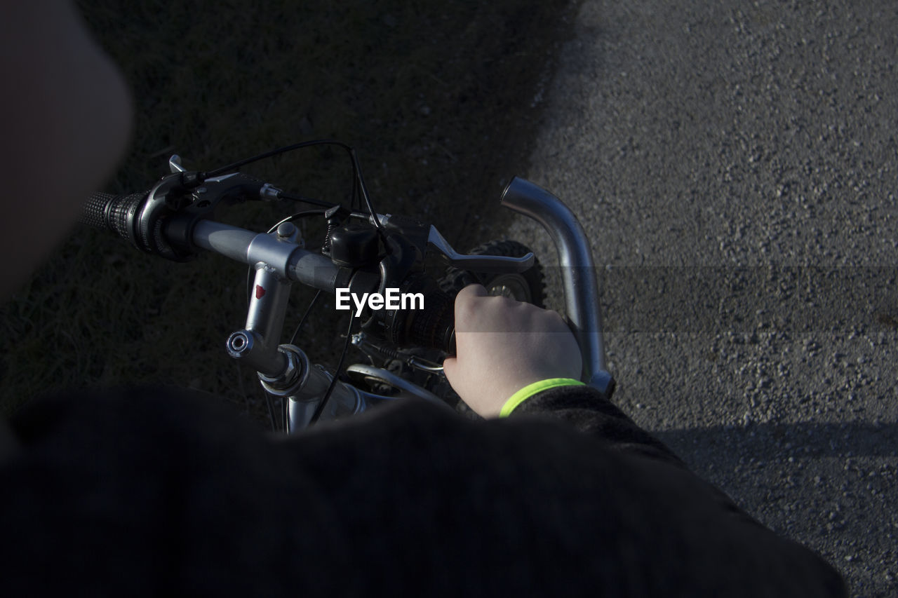 Midsection of person riding bicycle on road