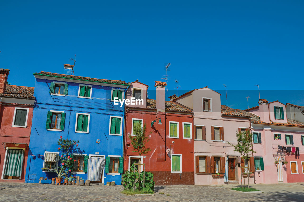 View of colorful houses on sunny day in burano, a gracious little town full of canals in italy.