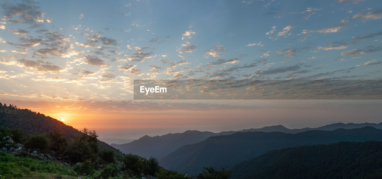 Silhouette view from top of mountains at sunrise with cloudy sky in gilan province, iran.