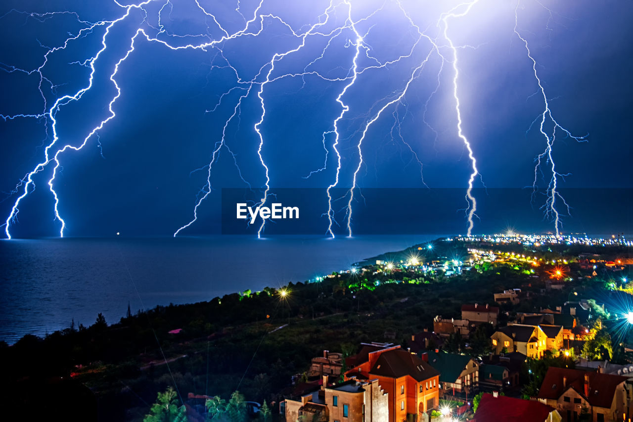 Night thunderstorm over a coastal city.