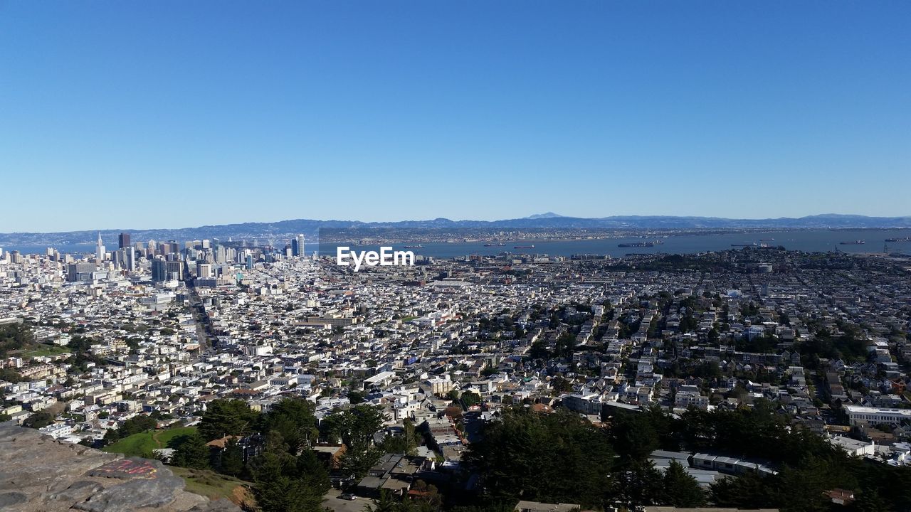 High angle view of cityscape against clear blue sky