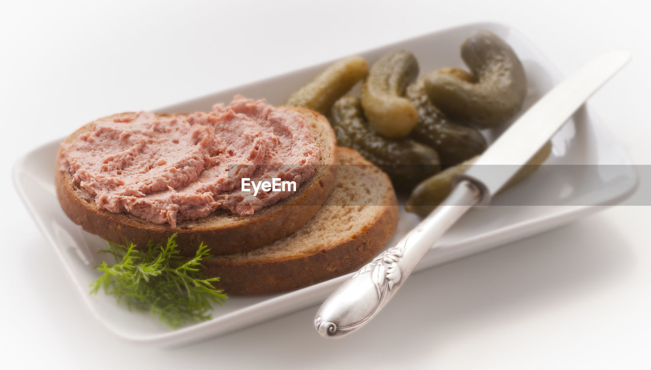 Close-up of breakfast served in plate over white background