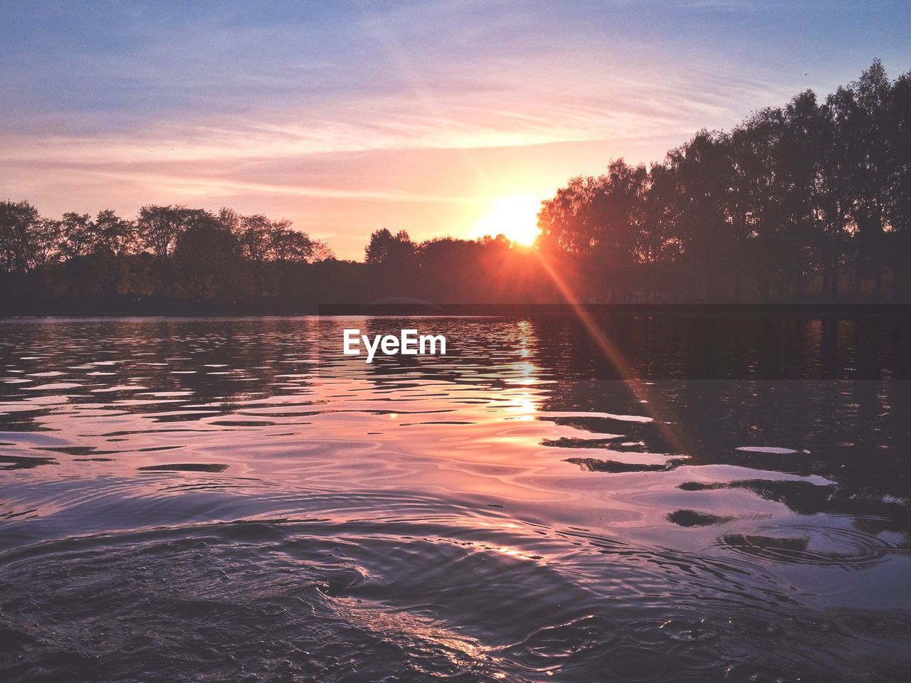 Scenic view of lake against sky at sunset