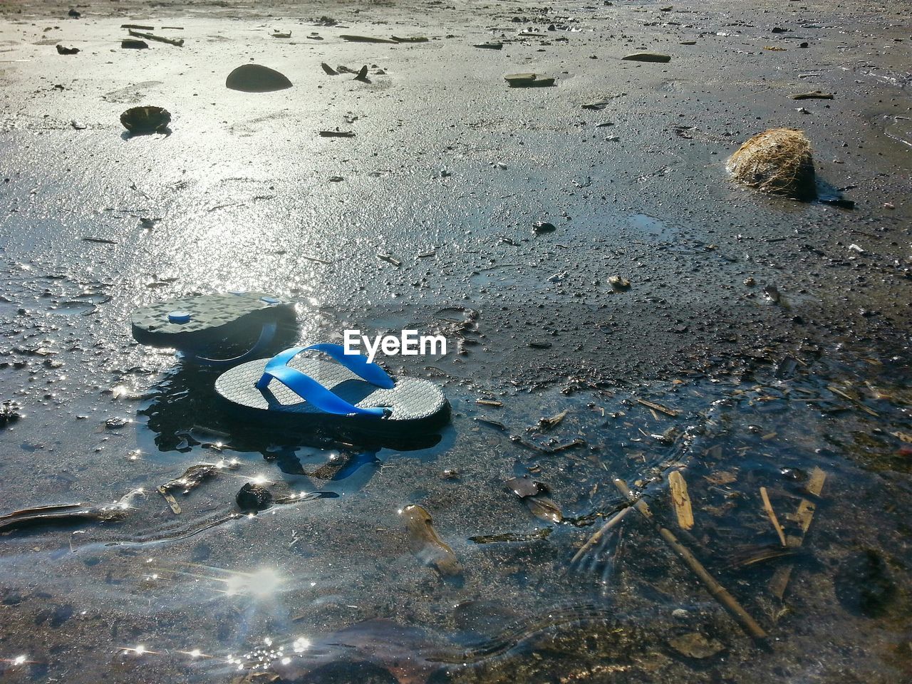 Close-up of slippers on sand at beach