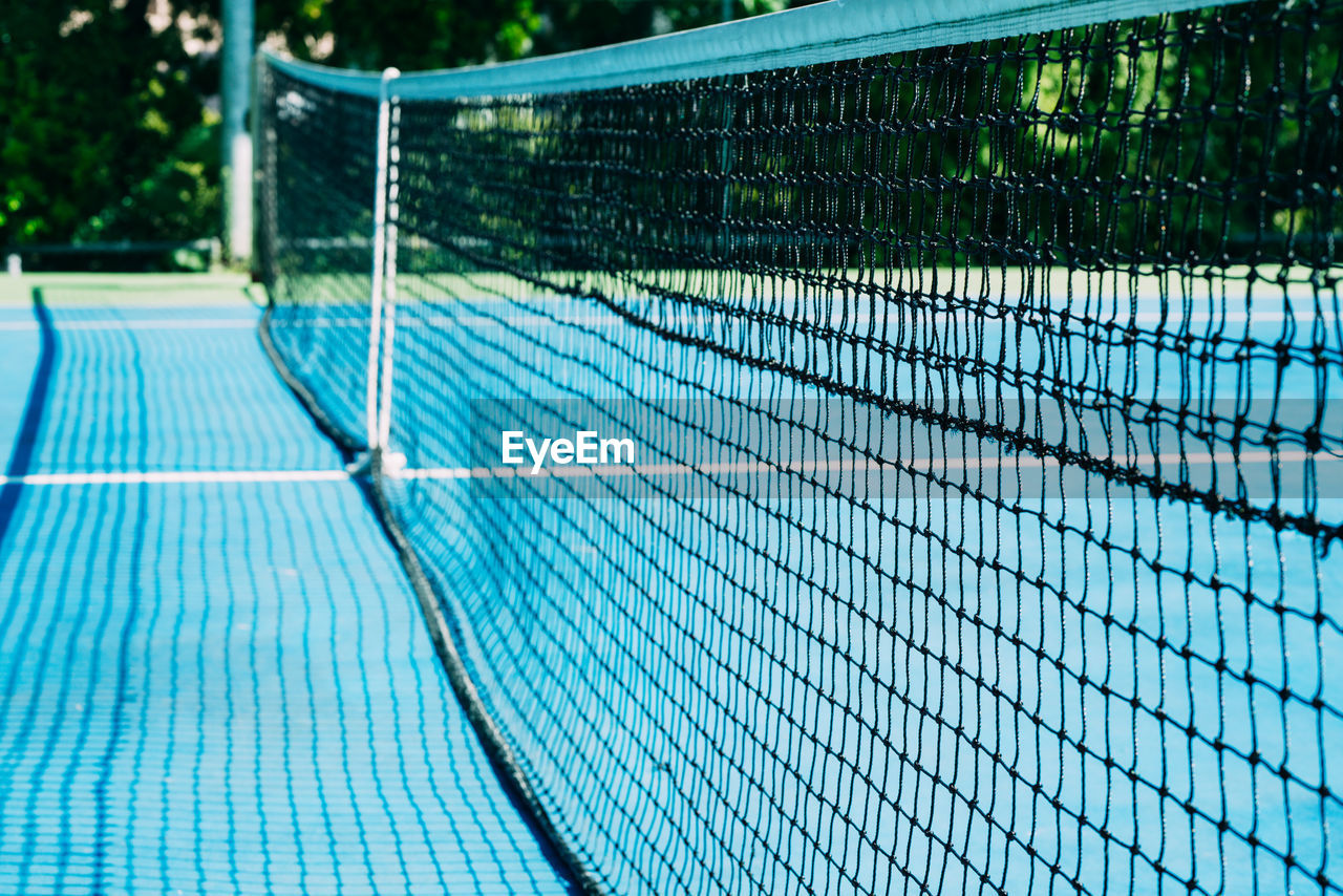 net, sports, tennis net, net - sports equipment, day, nature, absence, no people, tennis, tennis court, fence, chain-link fencing, outdoors, outdoor structure, plant, sunlight, blue, tree, pattern, empty, green, netting