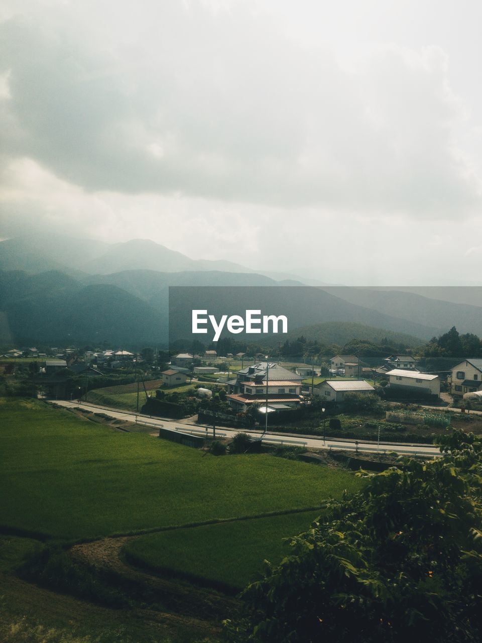 Scenic view of field by buildings against sky