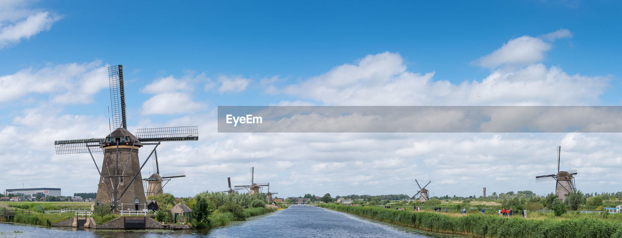 Traditional windmills on field against sky