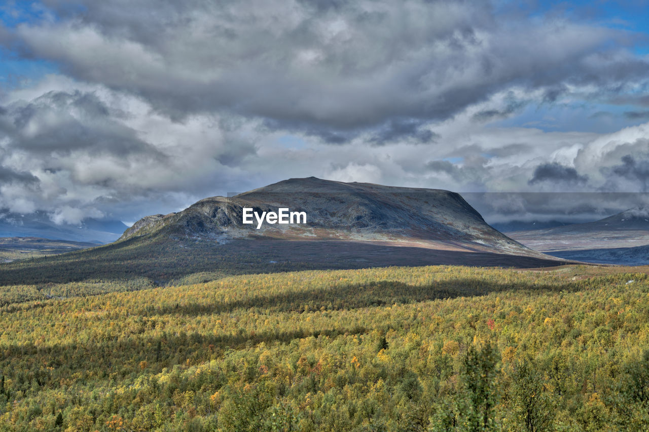 Scenic view of mountains against cloudy sky