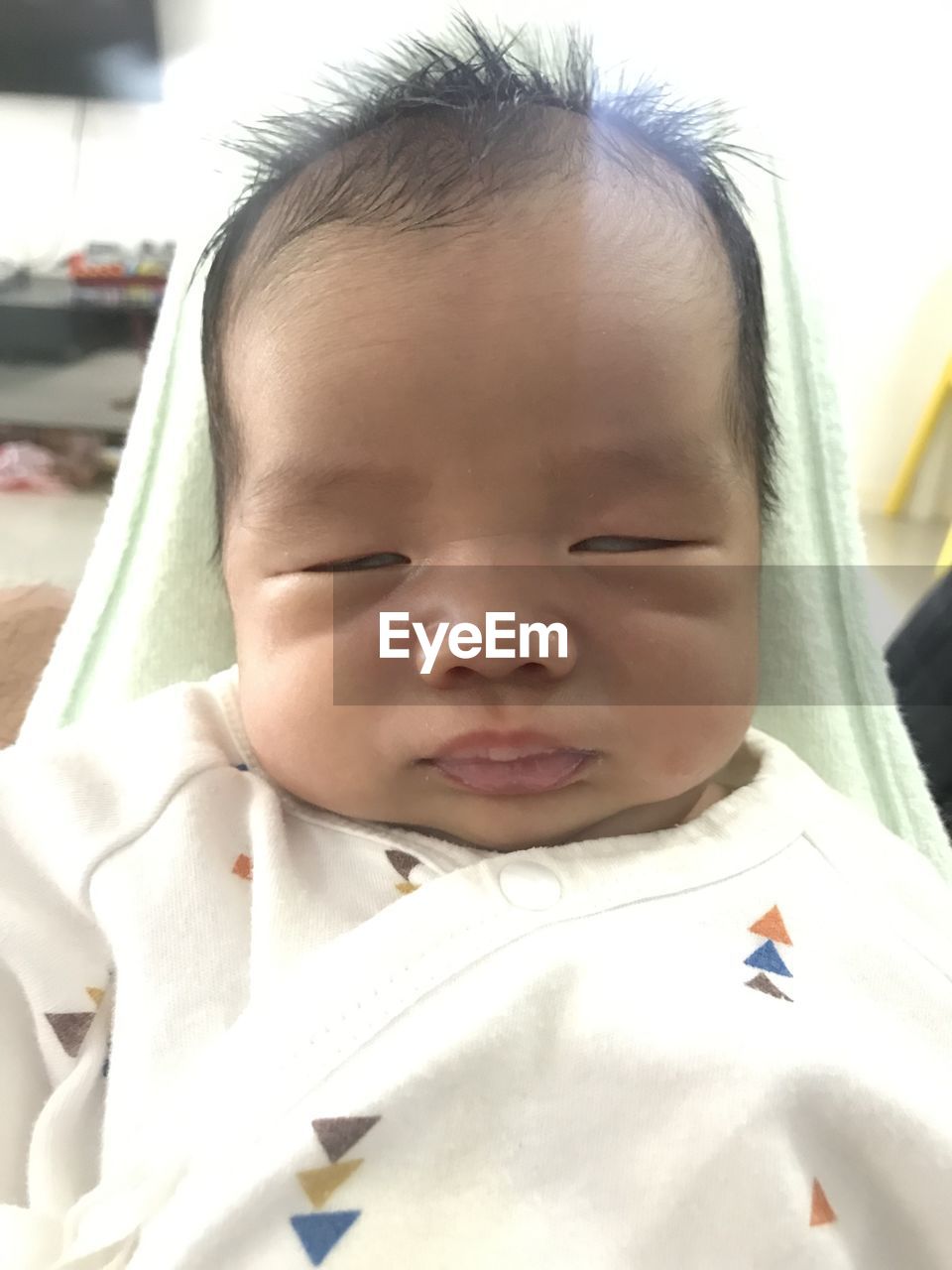 Close-up of cute baby boy with eyes closed at home