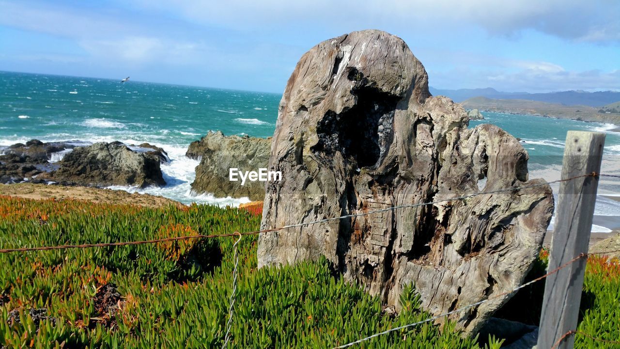 SCENIC VIEW OF SEA BY ROCKS AGAINST SKY