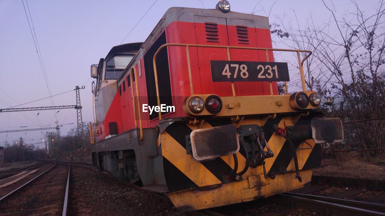 TRAIN BY RAILROAD TRACK AGAINST SKY