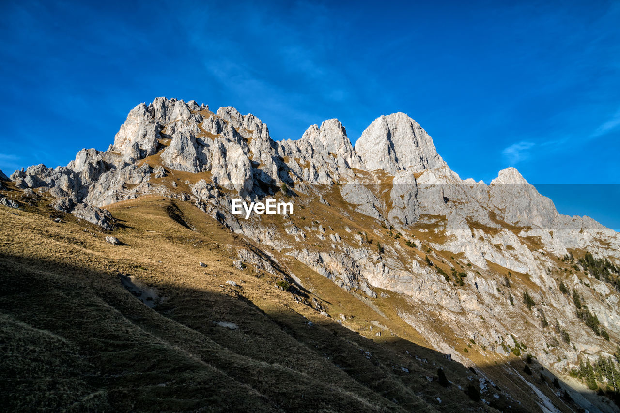 LOW ANGLE VIEW OF ROCK FORMATIONS AGAINST SKY