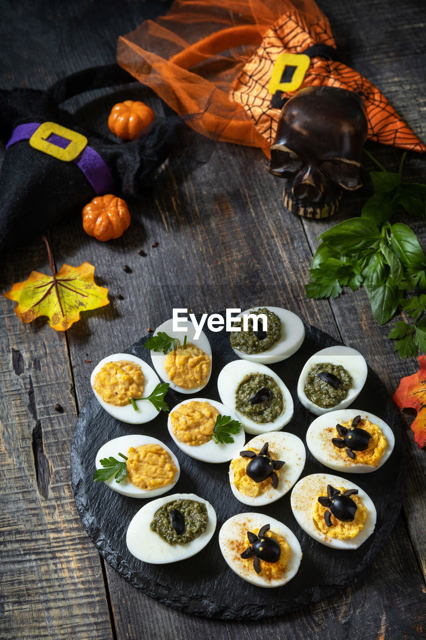 Halloween funny idea for party food. halloween creative set stuffed eggs on a wooden table.