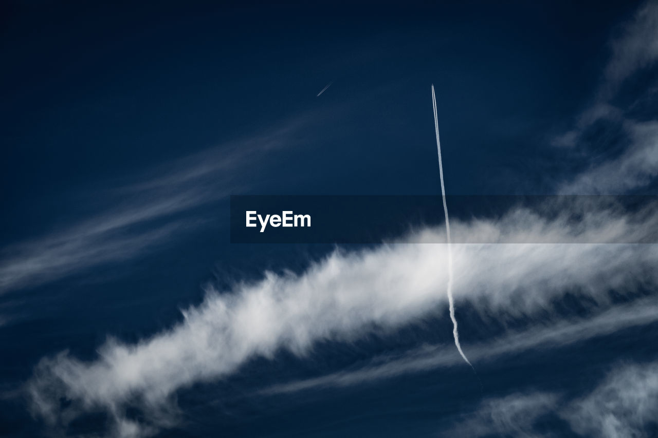 LOW ANGLE VIEW OF VAPOR TRAILS AGAINST SKY