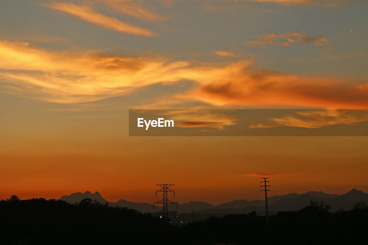 Silhouette electricity pylon against sky during sunset