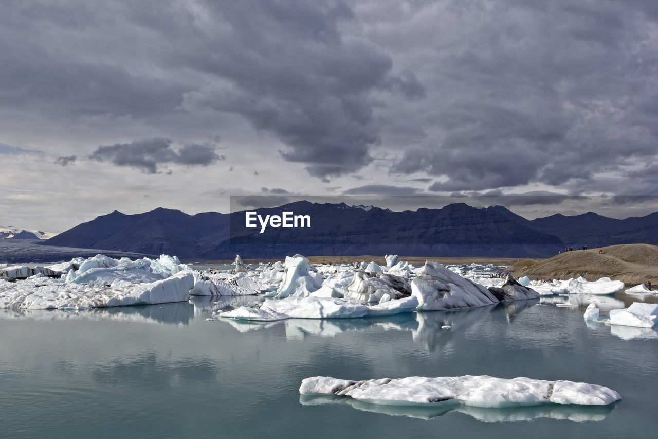 Scenic view of frozen lake against cloudy sky