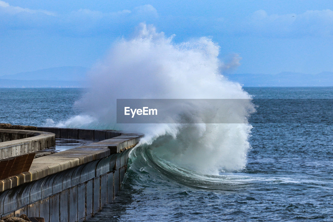 Big ocean wave hitting pier. storm waves