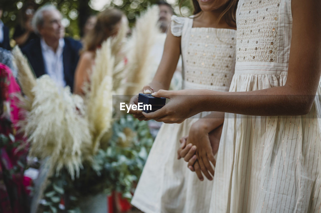 Midsection of cute girls carrying the rings at wedding ceremony