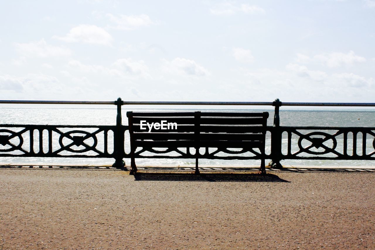 Empty bench overlooking calm sea