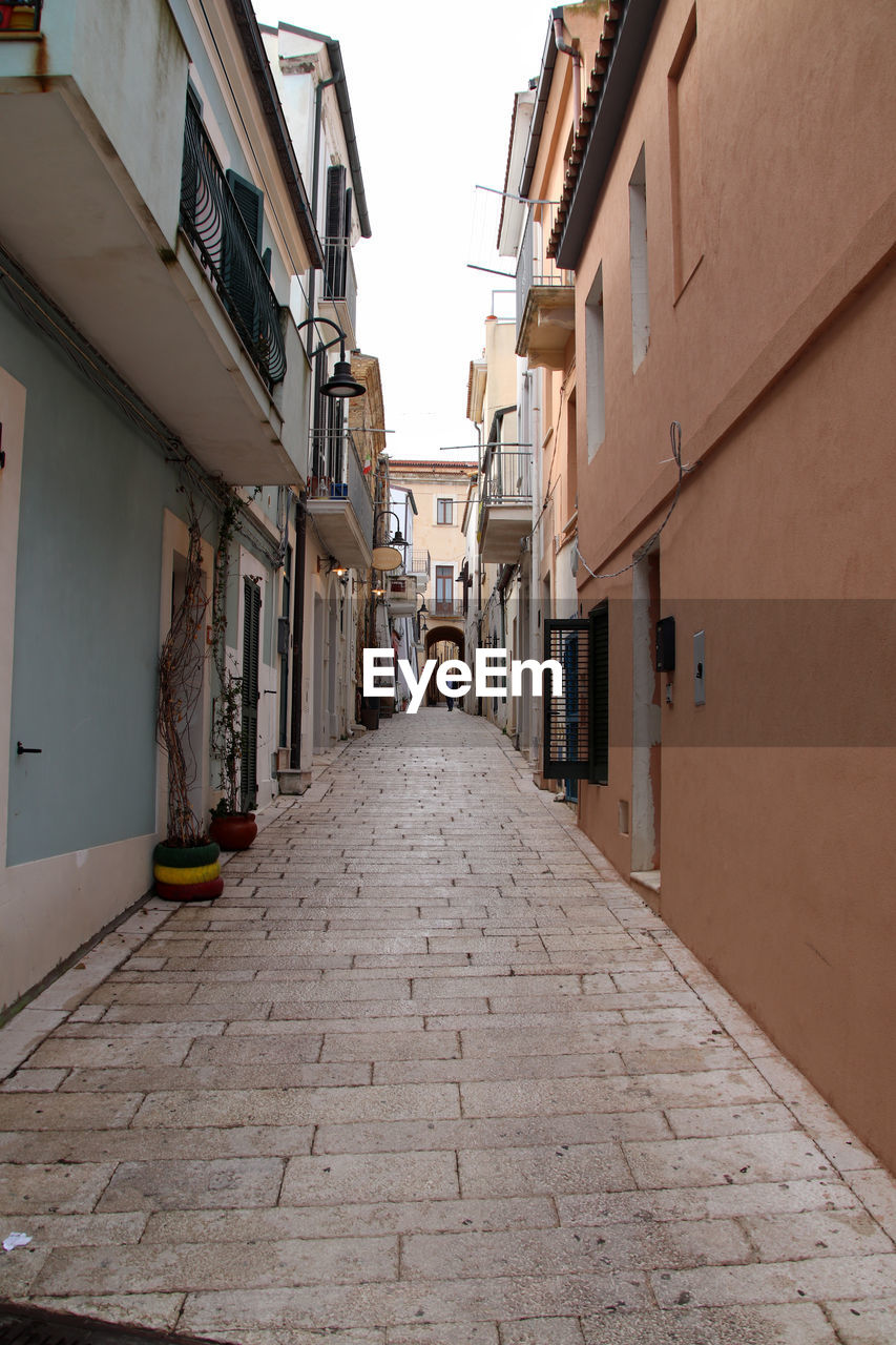 architecture, building exterior, alley, built structure, street, road, city, building, town, lane, residential district, neighbourhood, the way forward, diminishing perspective, footpath, road surface, cobblestone, house, infrastructure, narrow, no people, sky, nature, wall, outdoors, day, travel destinations, old