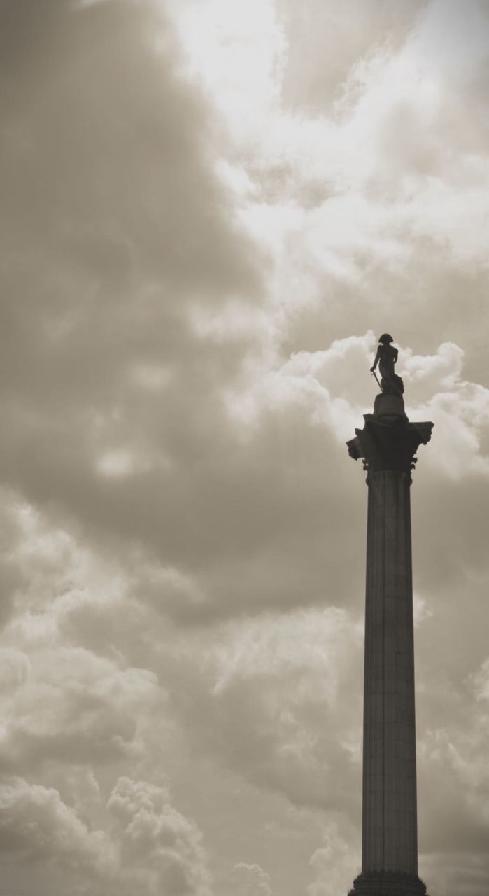 Low angle view of nelsons column against cloudy sky