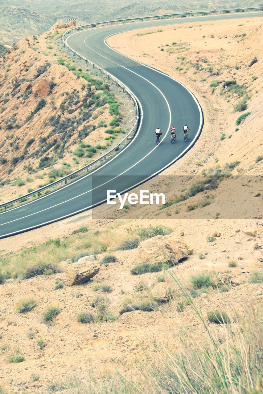 High angle view of people cycling on country road